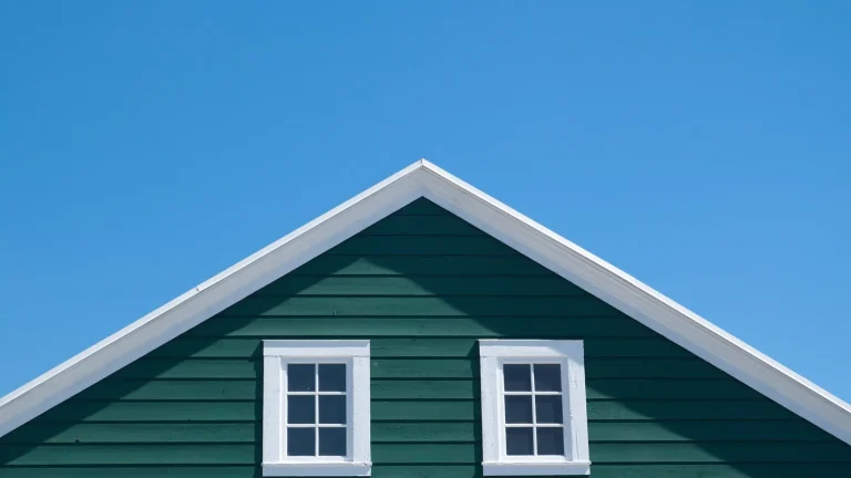 Green lap siding with white trim on a home gable, siding installation in Olympia