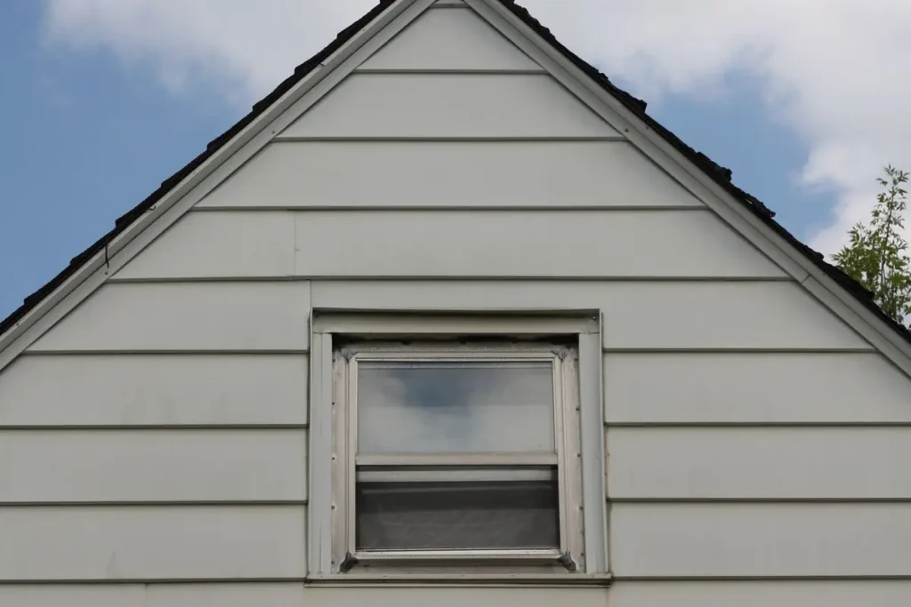 Gray lap siding on a home gable with a new roof edge