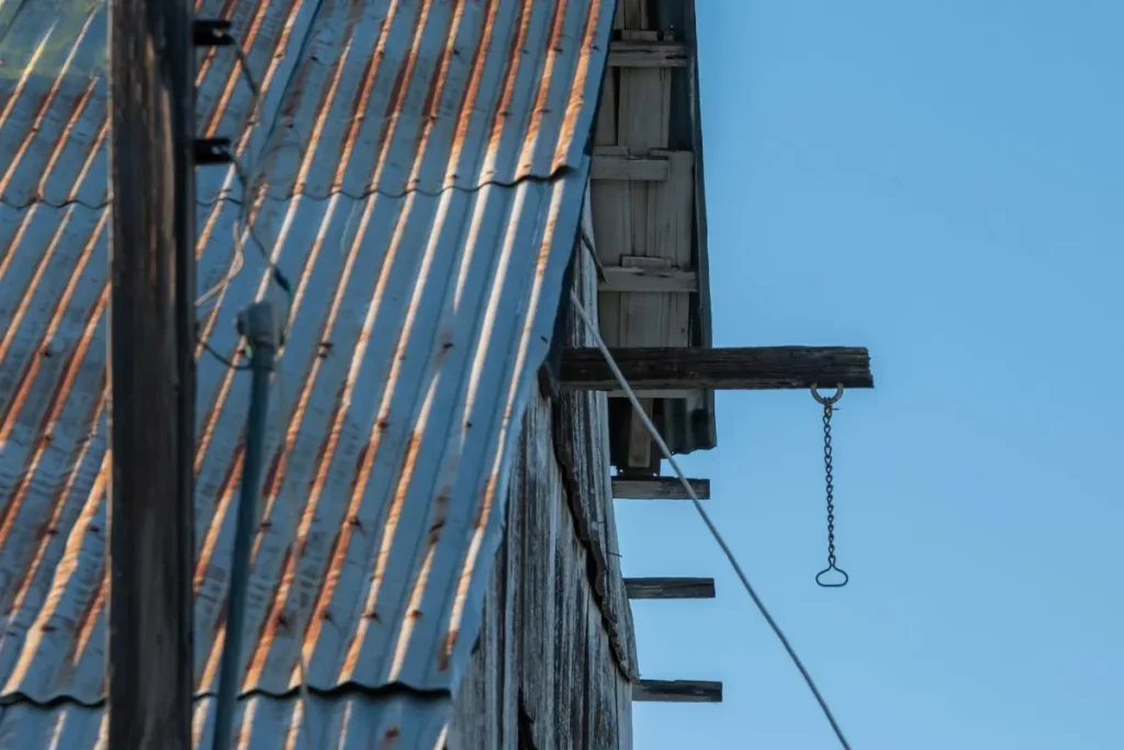 Metal roof panels against a blue sky, compared with asphalt shingles